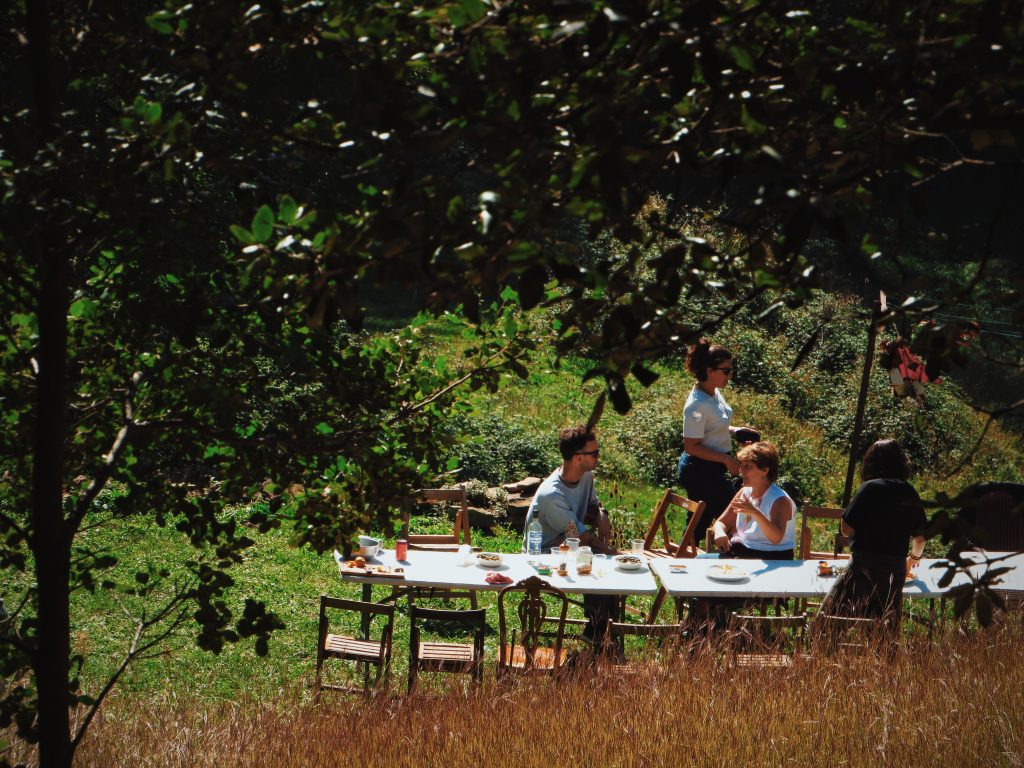 Grupo de residentes en una reunión semanal al aire libre en FEM, coliving rural España vida comunitaria en el Pirineo.